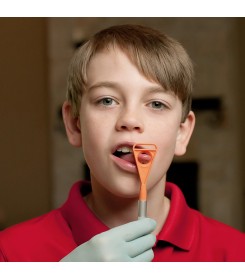 Chłopczyk ćwiczy boczne ruchy języka stosując szpatułkę do wibratorów logopedycznych tongue