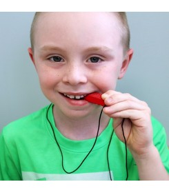 chłopczyk ćwiczy żuchwę na naszyjniku logopedycznym