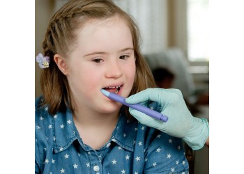 Dziewczynka z zespołem Downa ćwiczy na gryzaku logopedycznym od ARK